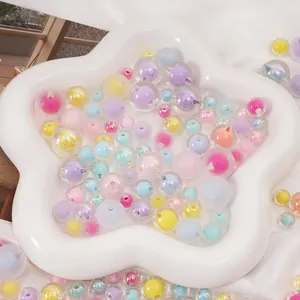 Détail de perles en acrylique dépolies colorées dans un plat étoilé pour création de bijoux