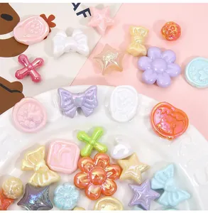 Close-up of colorful acrylic bow and heart beads with iridescent pearl finish for DIY