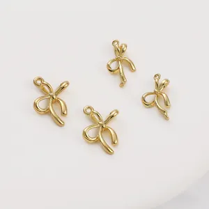 Dettaglio dei ciondoli a fiocco placcati in oro 14K con finitura lucida e doppi anelli