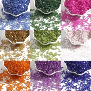 Nine colors of 2mm glass bugle beads in white bowls for DIY jewelry making