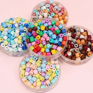 Close-up of colorful 6x6mm glass barrel beads for DIY jewelry making in clear containers