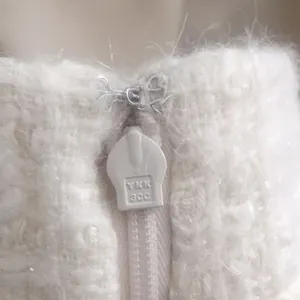 Detalle de prenda de punto blanca de mohair con cremallera metálica YKK 3CC de alta calidad
