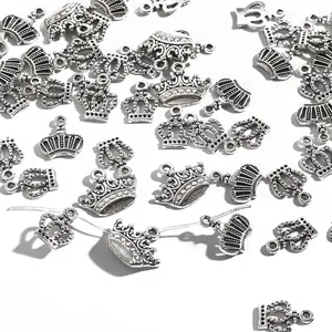 Nahaufnahme von silbernen Kronenanhängern aus Legierung mit Gravur für DIY-Schmuck