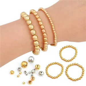 Doe-het-zelf sieradenset met goud- en zilveren kralen, armbanden en ringen op wit decor
