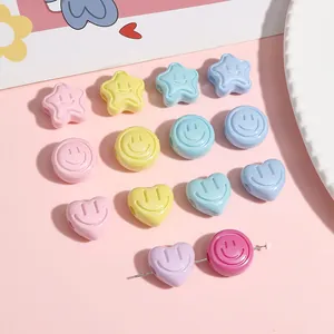 Macro shot of 18mm cream pastel acrylic beads in star and heart shapes for DIY jewelry