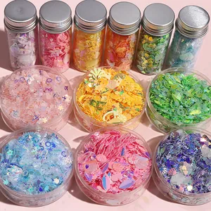 Detail van diverse kleurrijke pailletten in ster- en schelpvorm voor DIY en nagelkunst