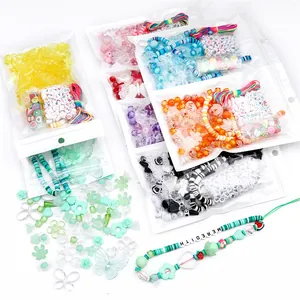 Detail eines bunten DIY-Perlensets mit Anhängern und grünem Handyband-Prototyp