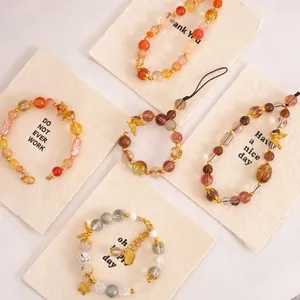 Detailed macro view of colorful glass beads and golden butterfly charms for DIY jewelry