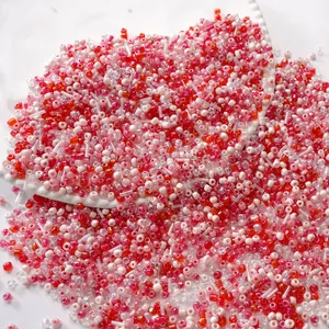 Mixed red and white glass seed beads in a white ceramic tray for DIY jewelry making