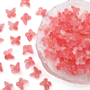 Pink translucent butterfly charms with gold loops displayed in a clear glass bowl