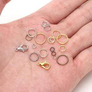 Assorted lobster clasps and jump rings in various metal finishes held in a palm