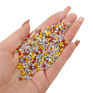 Colorful 3mm striped glass seed beads held in hand for handmade DIY jewelry making