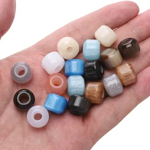 Dettaglio di perle in resina 12x10mm a foro largo in colori assortiti tenute in mano