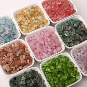 Detailed top view of various colorful irregular glass bead stone fragments in white bowls