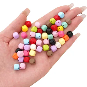 Hand holding 8mm mixed color acrylic square cube beads for DIY jewelry making