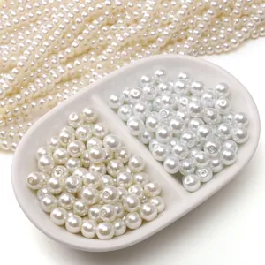 Dettaglio di perle di vetro bianche e crema in piatto di ceramica per gioielli fai da te