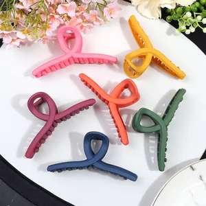 Set of 6 large matte cross hair clips in vibrant colors on a decorative floral background