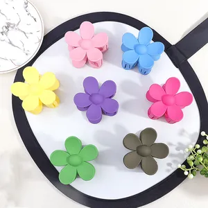 Flat lay of colorful matte flower hair claws in pink, blue, yellow, and green tones