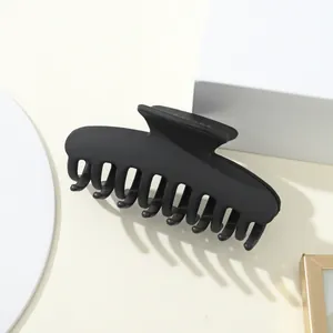 Vista macro di un grande fermaglio per capelli nero opaco con design multi-dente per lo styling