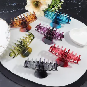 Set of six gradient resin hair claws in various colors on a white marble background
