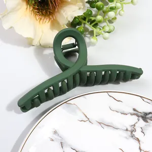 Detail view of large dark green matte claw clip with cross twist design and strong grip teeth