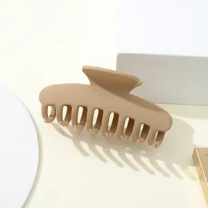Macro di una grande clip a molla kaki opaca per acconciature di capelli folti