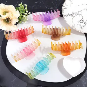 Detailed overhead view of six large matte gradient shark hair clips in various colors