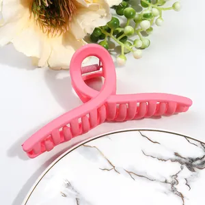 Close-up of matte candy pink hair claw clip showing wavy teeth and spring mechanism