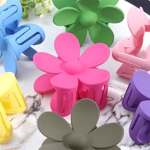 Matte flower hair claws in multiple candy colors on a marble display plate