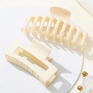 Detailweergave van twee crèmekleurige matte haarklemmen met gladde, afgeronde tanden