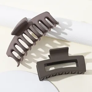 Detail van twee mat koffiebruine haarklemmen met elegante matte rubberen coatingtextuur