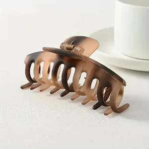 Detail of a matte tortoiseshell hair claw clip with a strong metal spring and gradient texture