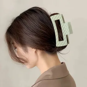 Detail van een mintgroene haarklem met gewatteerd mat patroon op een model