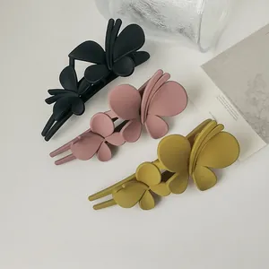 Set of three matte butterfly hair clips in black, dusty pink, and mustard yellow colors