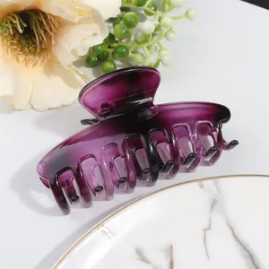 Detail of a large translucent purple resin hair claw clip with interlocking teeth design