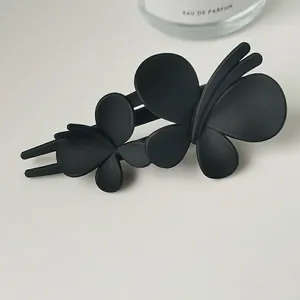 Close-up of matte black butterfly hair claw clip with double butterfly design