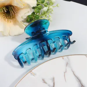 Detail of blue gradient hair claw clip with glossy finish on a decorative marble plate
