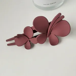 Detailed macro view of a matte dark rose pink double butterfly hair claw clip