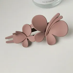 Detail of matte butterfly hair clip in dusty rose pink for bun hairstyles