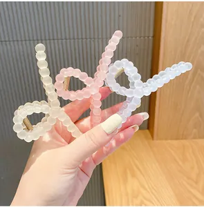 Close-up of macaron frosted bead hair claws in cream white, soft pink, and ice blue colors