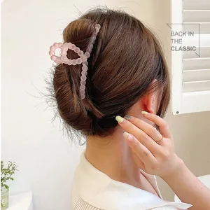 Pink matte claw clip with round bead design shown on woman's updo hairstyle
