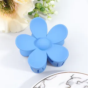 Macro shot of matte sky blue flower claw clip showing textured petals and inner teeth