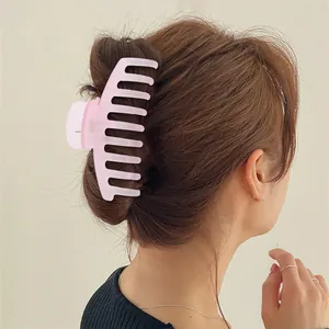 Matte pink 11cm shark hair claw clip for women shown on back of head with elegant hairstyle