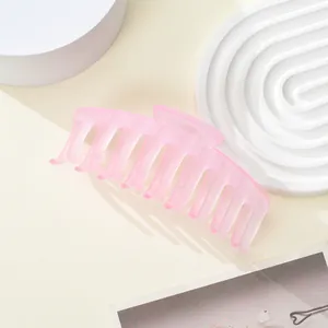 Detail view of pink matte translucent large hair claw clip on minimalist display stand