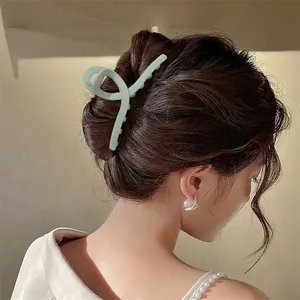 Detail einer 13cm mattgrünen Haarklammer, die das Haar zu einer eleganten Hochsteckfrisur hält
