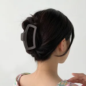 Detail einer großen matten braunen geometrischen Haarklammer für Hochsteckfrisuren im Haar