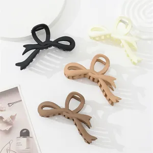 Detail of matte bow hair claws in four earthy colors with a durable metal spring