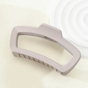 Detailansicht der mattgrau-violetten geometrischen Haarklammer mit Trapez-Design