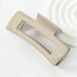 Detail showing the glossy coffee-colored rectangular hair claw clip with smooth finish