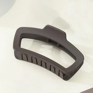 Detailansicht einer matten, dunkelbraunen geometrischen Haarklammer mit rechteckigem Design